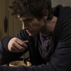 a man sitting at a table eating from a bowl