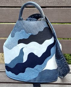 a denim bag sitting on top of a wooden bench