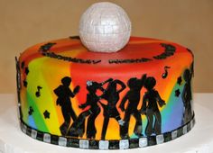 there is a colorful cake decorated with people and a white ball on top of it