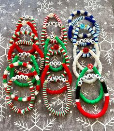 several bracelets are laid out on a table with snowflakes in the background