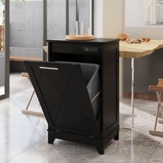 a black dishwasher sitting on top of a kitchen floor next to a table