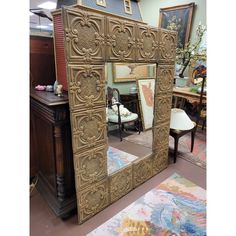 an ornately carved mirror is on display in a room with other furniture and decor