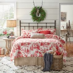 a bed room with a neatly made bed and a wreath on the wall