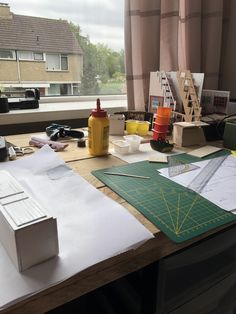 a table with paper, scissors and other crafting supplies sitting on top of it