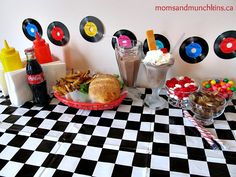 a table topped with lots of food next to cups filled with ice cream and candy