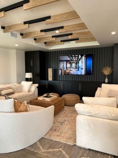 a living room filled with furniture and a flat screen tv mounted to the wall above it