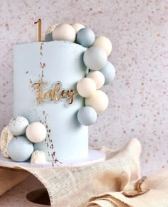 a blue cake with white and grey decorations on it