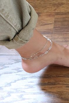 Upgrade your ankle game with our 2-row stainless steel paperclip anklet! Available in two stylish colors, this anklet is the perfect finishing touch to any outfit. Made with high-quality materials, it's sure to make a lasting impression. Don't miss out on adding this trendy piece to your jewelry collection! DETAILS: * Stainless steel, 18k gold PVD MEASUREMENTS: * Length: 9" + 1" inch extender CARING TIPS: * Avoid contact with water, sweat, lotions & perfumes as these can tarnish the jewelry * Keep jewelry clean and dry * We recommend using polishing cloths to restore the shine to your jewelry OTHER INFORMATION: * All items are packaged in elegant jewelry pouches * Have any questions? Feel free to contact us. We reply fast! MORE FROM US https://leycorjewelry.etsy.com Instagram: @leycorjewel Silver Chain Anklet, Anklet Silver, Anklet For Women, Simple Chain, Women Anklets, Gold Anklet, Double Chain, Anklet Bracelet, Chain Anklet