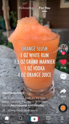 the orange slush is in a glass on top of a stone table with text above it