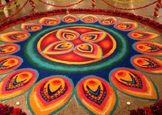 a colorful carpet with an intricate design in the center and red flowers on the floor