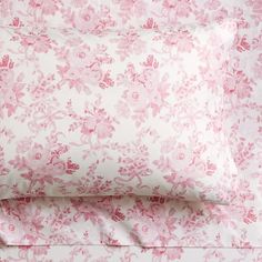 the pink and white bedding is made up with floral print on it's sheets