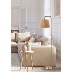 a living room scene with focus on the floor lamp and sofa in the foreground