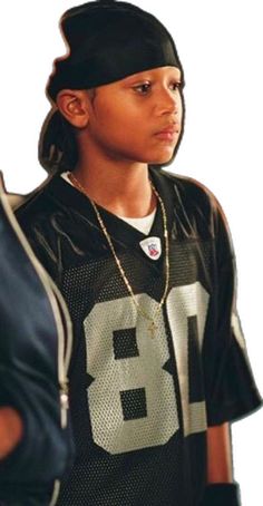 a young boy wearing a football jersey and hat