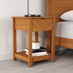 a bedside table with books and a lamp on it