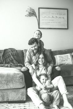 a black and white photo of a family sitting on the floor in their living room