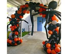 an outdoor halloween decoration with orange and black balloons in the shape of a giant spider