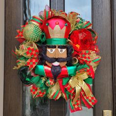 a christmas wreath with a man's face on it and red, green and gold decorations