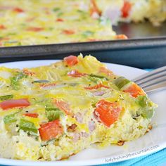 a piece of vegetable quiche on a plate with a fork next to the casserole