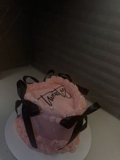 a pink and black cake with the name tiffany on it sitting on a white plate