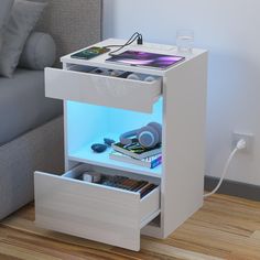 a white night stand with two drawers on the bottom and one drawer open to show items