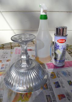 a bottle of cleaner next to a silver candle holder on top of a paper towel