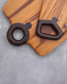 two wooden cutting boards sitting on top of a table next to each other with handles