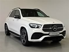 a white mercedes gle suv parked in a room with no one on the floor