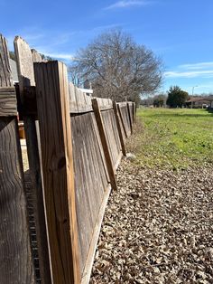 a wooden fence with leaves on the ground