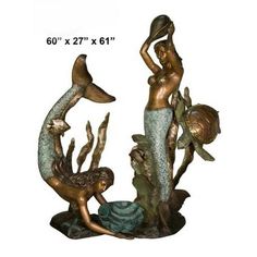 two mermaid statues are shown with one holding a fish and the other sitting on a rock