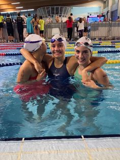 three women are in the swimming pool with their arms around each other as they smile