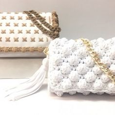 two white crocheted bags sitting on top of a table next to each other