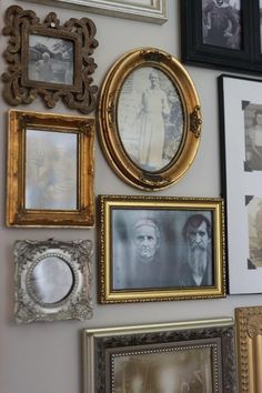 a wall with many different framed pictures on it