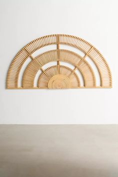 a wall sculpture made out of wicker on top of a wooden table next to a white wall