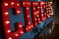 toy elephants are standing next to a lighted sign