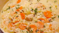 carrots, chicken and rice soup in a white bowl