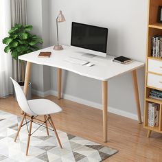 a white desk with a computer on it and a bookcase in the corner next to it