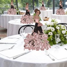 a table topped with lots of white tables covered in plates and silverware next to tall vases filled with flowers