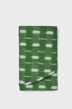 a green and white napkin on a white background with an uneven pattern in the middle