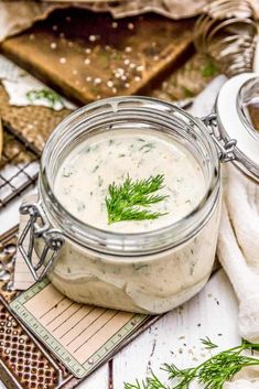 a jar filled with white sauce sitting on top of a table next to other items