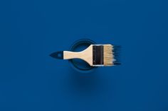 a paint brush with a black bristles sticking out of it's side on a blue background