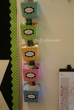 the door is decorated with colorful boxes and magnets for each individual's name