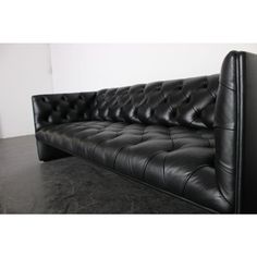 a black leather couch sitting on top of a floor