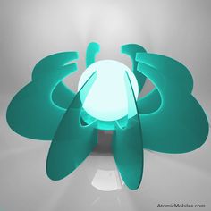 a green lamp sitting on top of a white table next to a light that looks like a flower