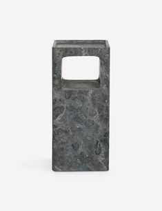 a gray marble vase with a hole in the middle on a white background, it is also used as a holder for something else