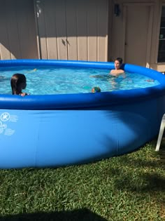 two children are playing in an above ground swimming pool while another child watches from the side