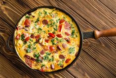 an omelet with ham, cheese and parsley in a cast iron skillet