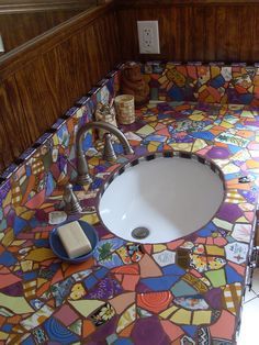 a bathroom with colorful tiles on the counter top