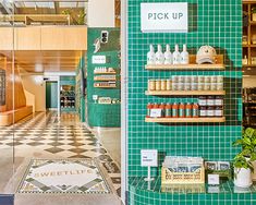 the inside of a store with green tiles and shelves