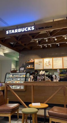 the inside of a starbucks coffee shop with seating and counter space for customers to sit at