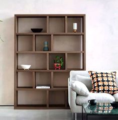 a living room filled with furniture and a book shelf next to a vase on top of a table